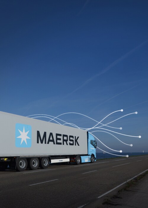 A Maersk truck drives along a coastal road.