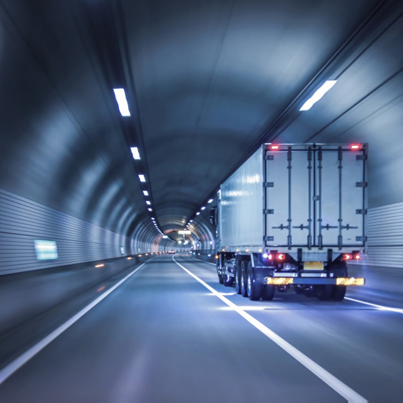 Truck driving through highway tunnel at night