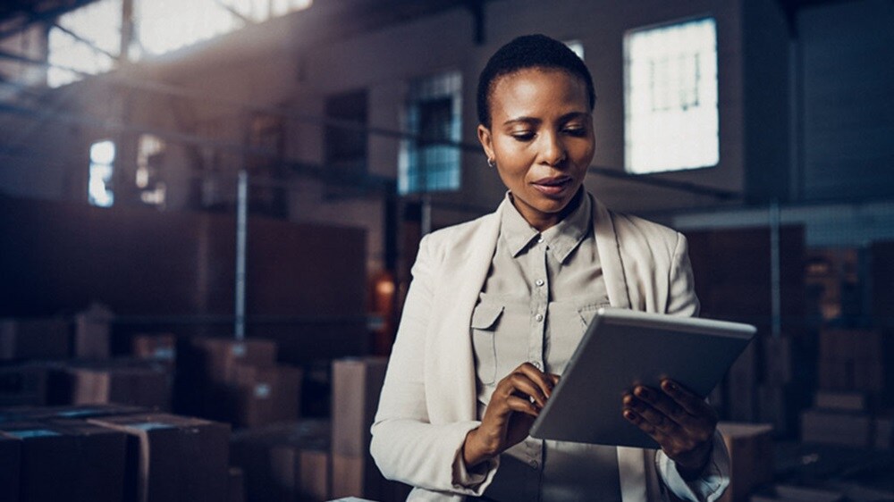 A black woman is standing in a warehouse