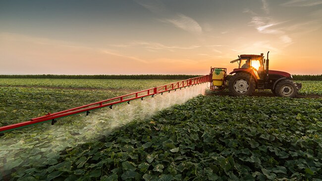 Tractor spraying pesticides in a farm