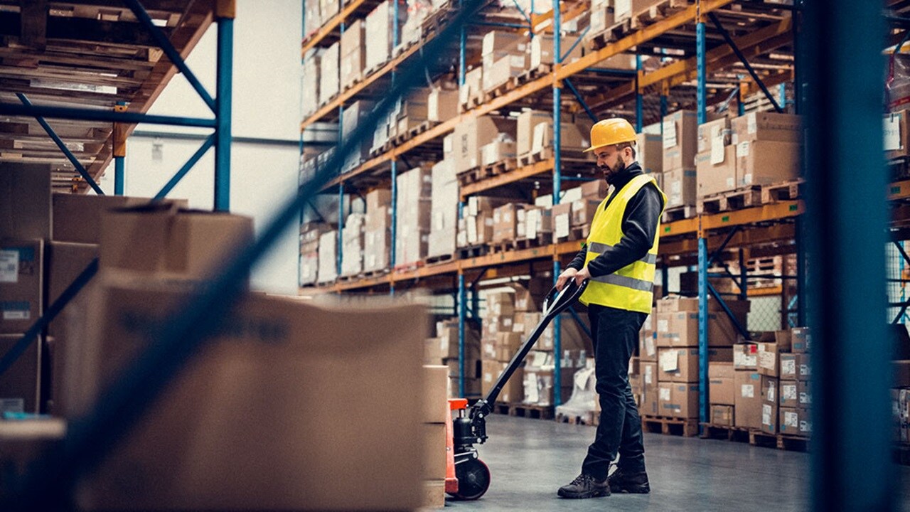 A man moving boxes in a warehouse