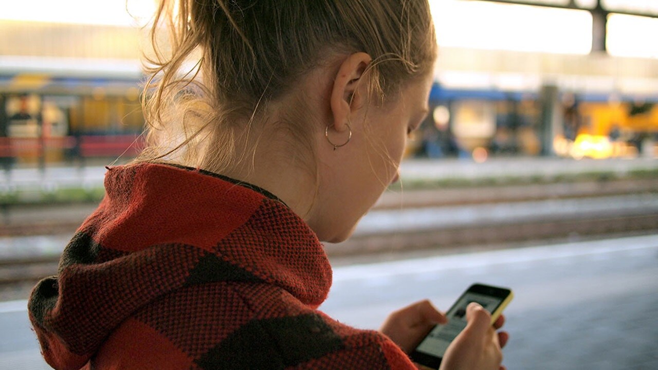 Young woman checks her smartphone