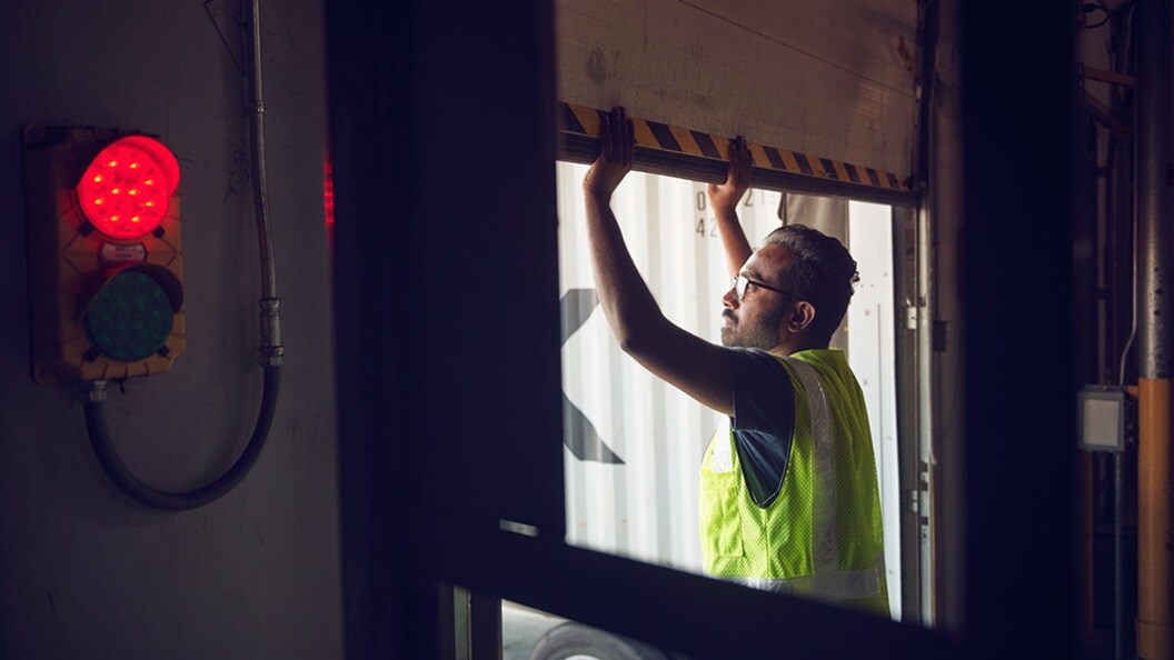 Man in a warehouse opening a garage door