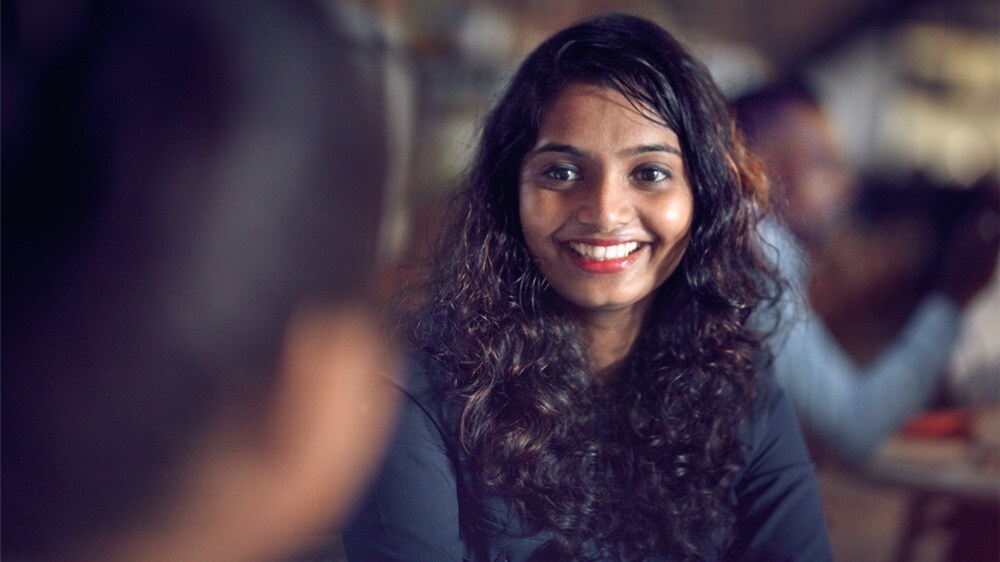 A kind smiley woman working with logistics support looks into the camera.