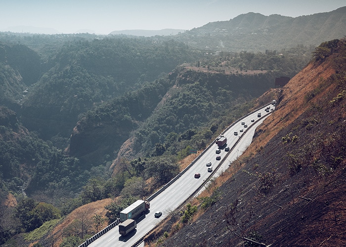 Eagle shot of multiple vehicles driving along the hills