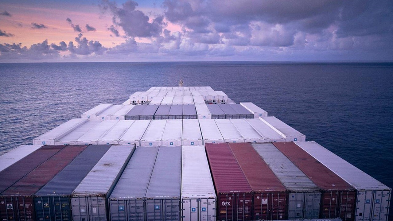 A loaded cargo ship sails towards the horizon symbolizing freight forwarding in 2024