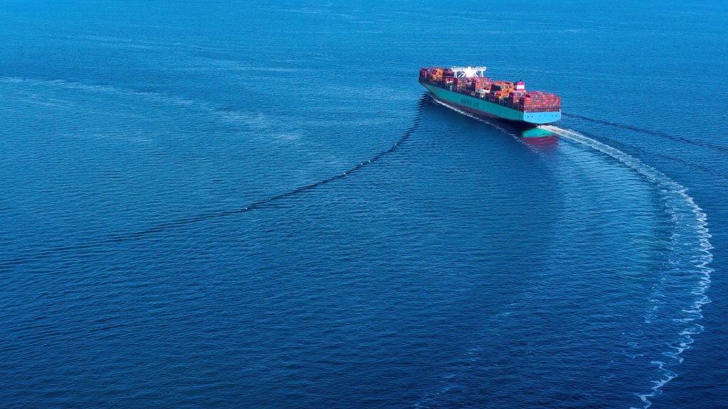 Maersk container vessel making a sharp turn at sea, symbolizing agility and resilience in global supply chain logistics.