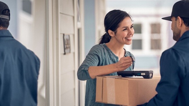 Smiling woman accepts e-commerce delivery