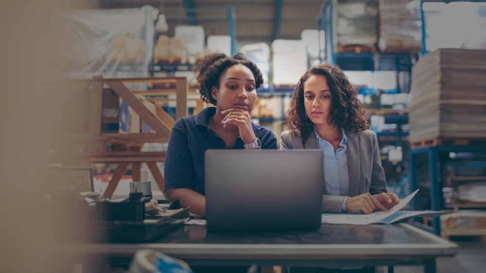 A couple of women looking for customs information on their laptop