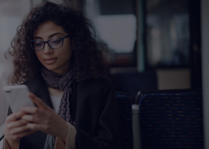 Young woman traveling by bus and using smart phone