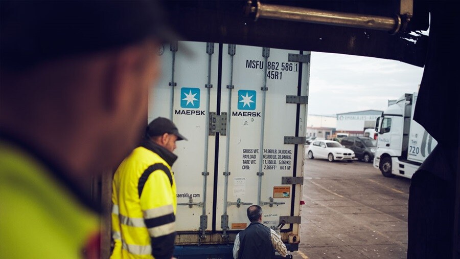 Maersk shipping container being handled at a loading dock
