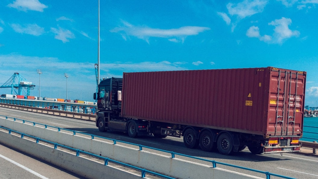 truck driving on the road carrying a freight container
