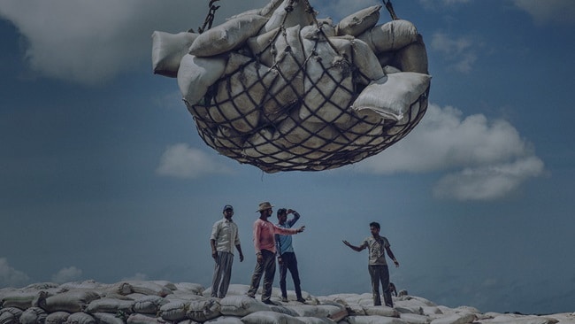 Emergency supply chain management – A group of men discussing about unloading the high-volume cargo.