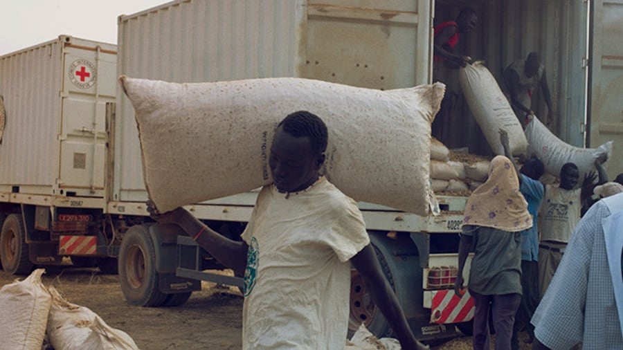 Men unloading a truck containing dry cargo in Africa.
