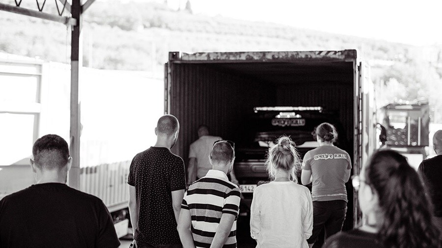Car in container with people around