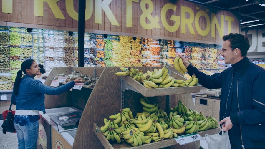 Male and a female picking bananas in a store