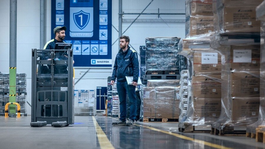 Two workers standing and conversing in a warehouse