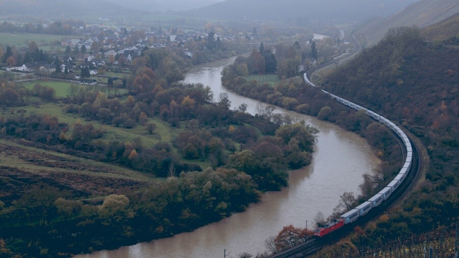 Birds eye shot of inland rail running along a river between the mountains