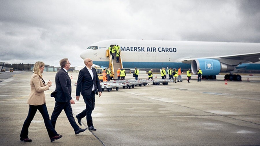 Team walking with plane in background