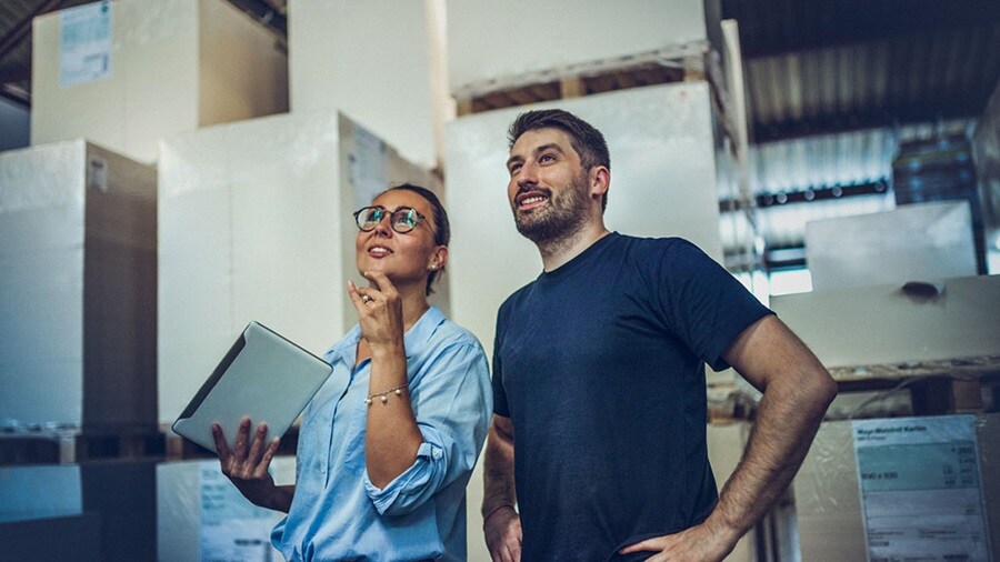 European business owners in a warehouse analysing ecommerce returns process.