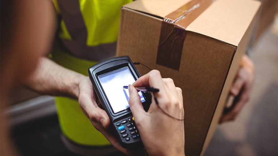 Parcel delivery driver taking a signature for receiving a parcel.