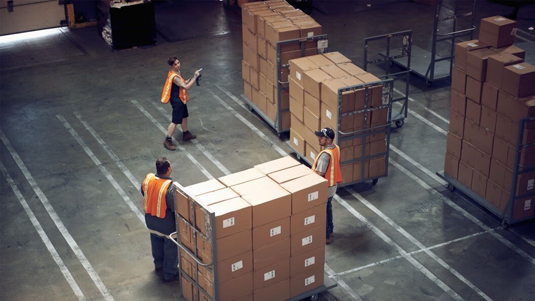 Employees moving packages around the facility. getting ready for transportation.