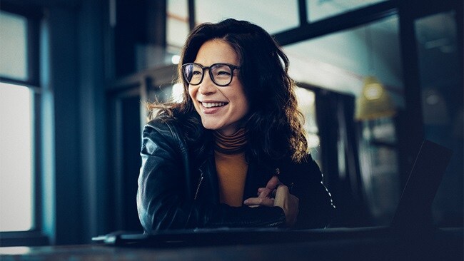Woman sitting in an office and smiling.