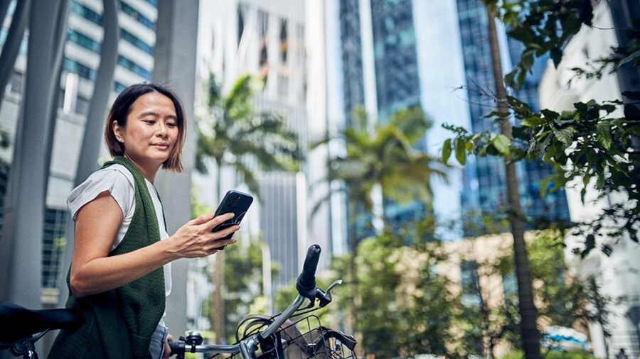 Woman looking at phone in Singapore city 