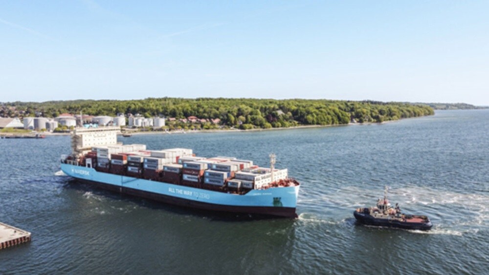 A large container ship is being towed by a tugboat across the water, showcasing maritime transportation in action.