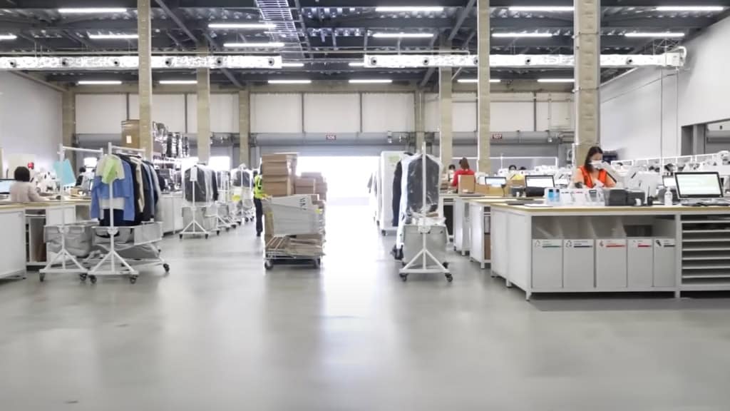 Modern logistics center with staff managing warehouse operations and clothing racks