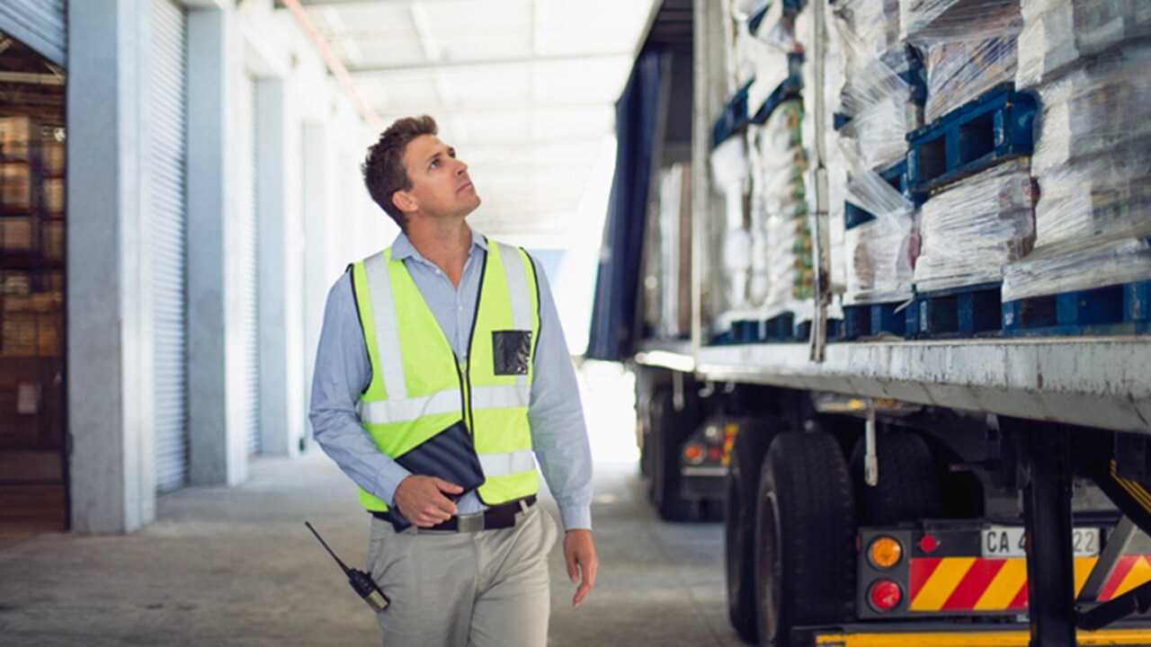 A male worker looking at cargo loaded in a truck.