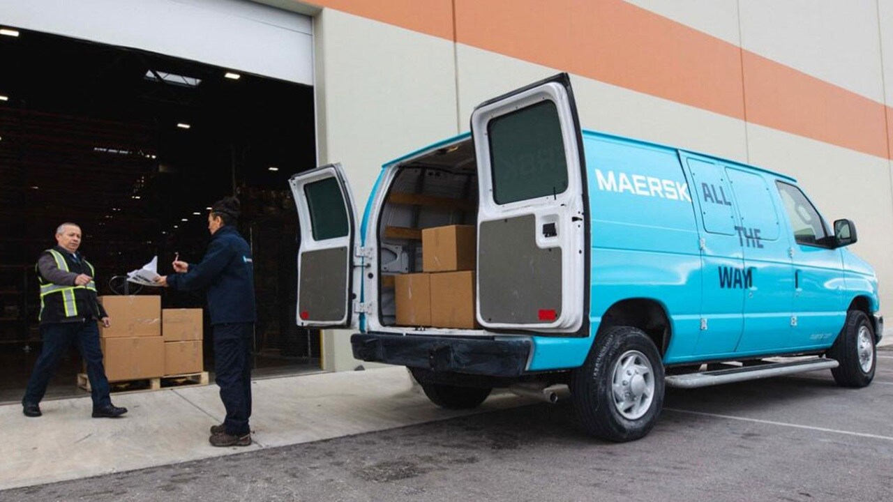 Maersk domestic parcel delivery van being loaded with boxes outside a warehouse, highlighting efficient ground logistics and last-mile services.