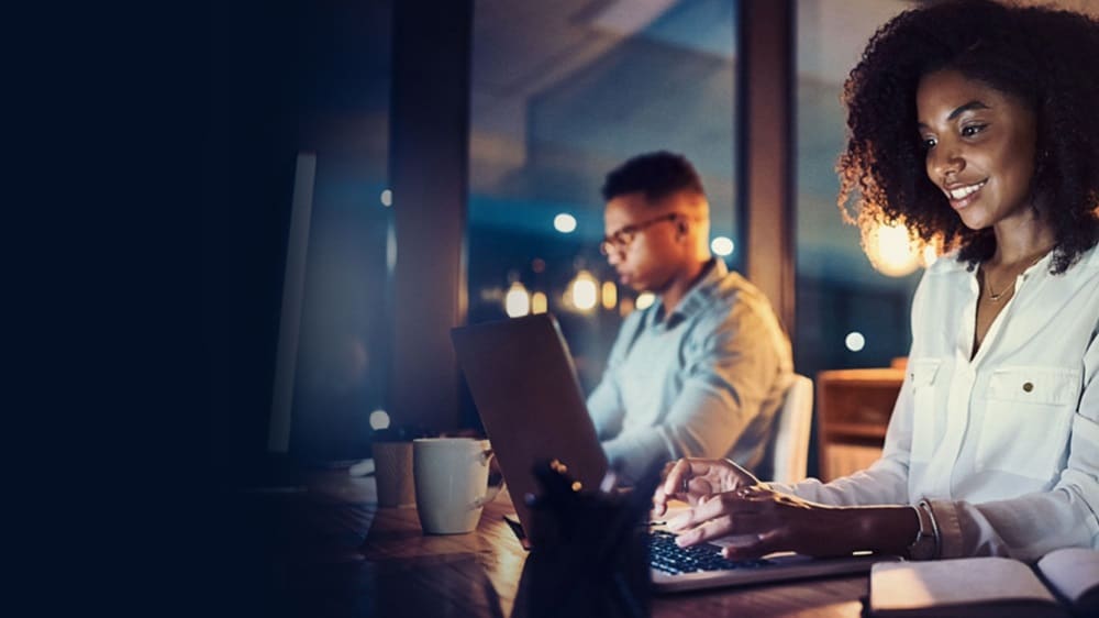 兩位專業(yè)人士使用筆記型電腦搜尋 AEO 必要文件清單的圖片。