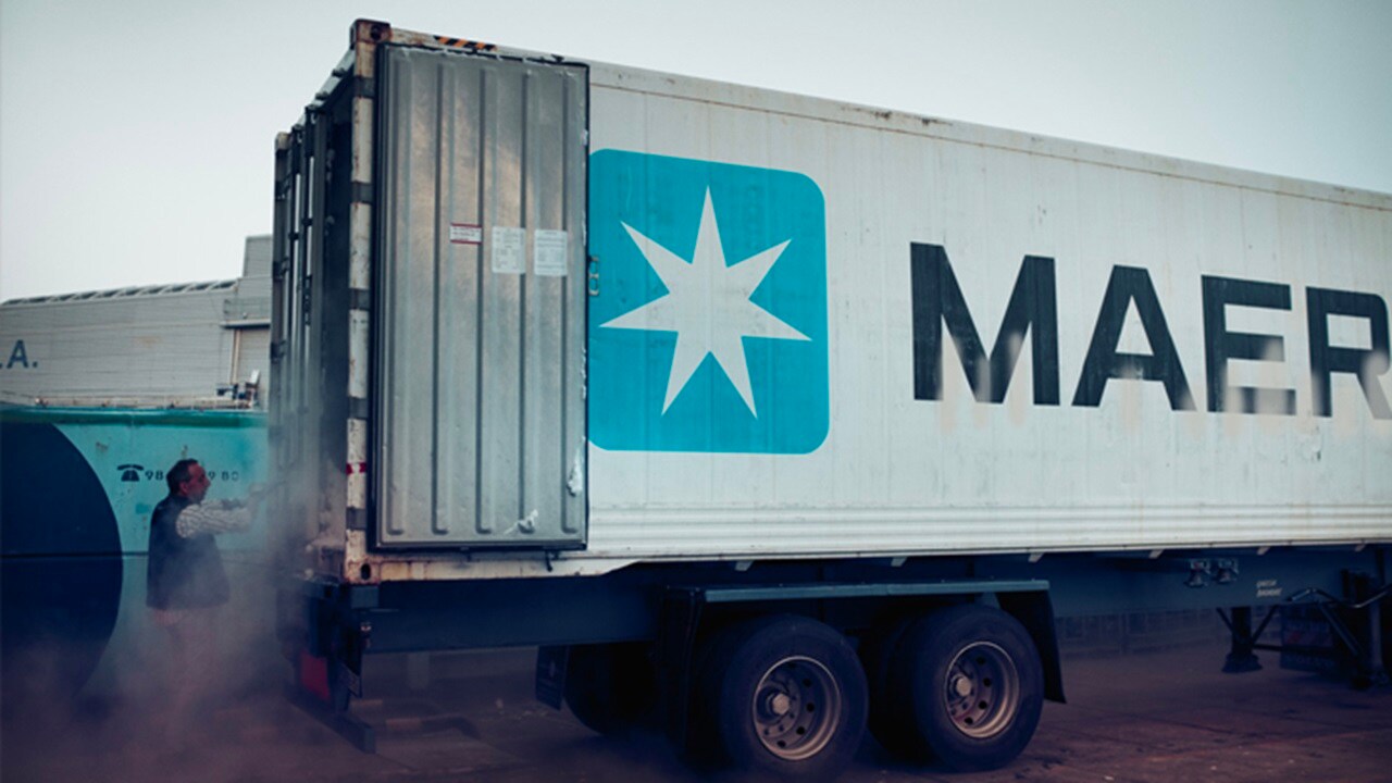 A Maersk container with doors opened and a man near it