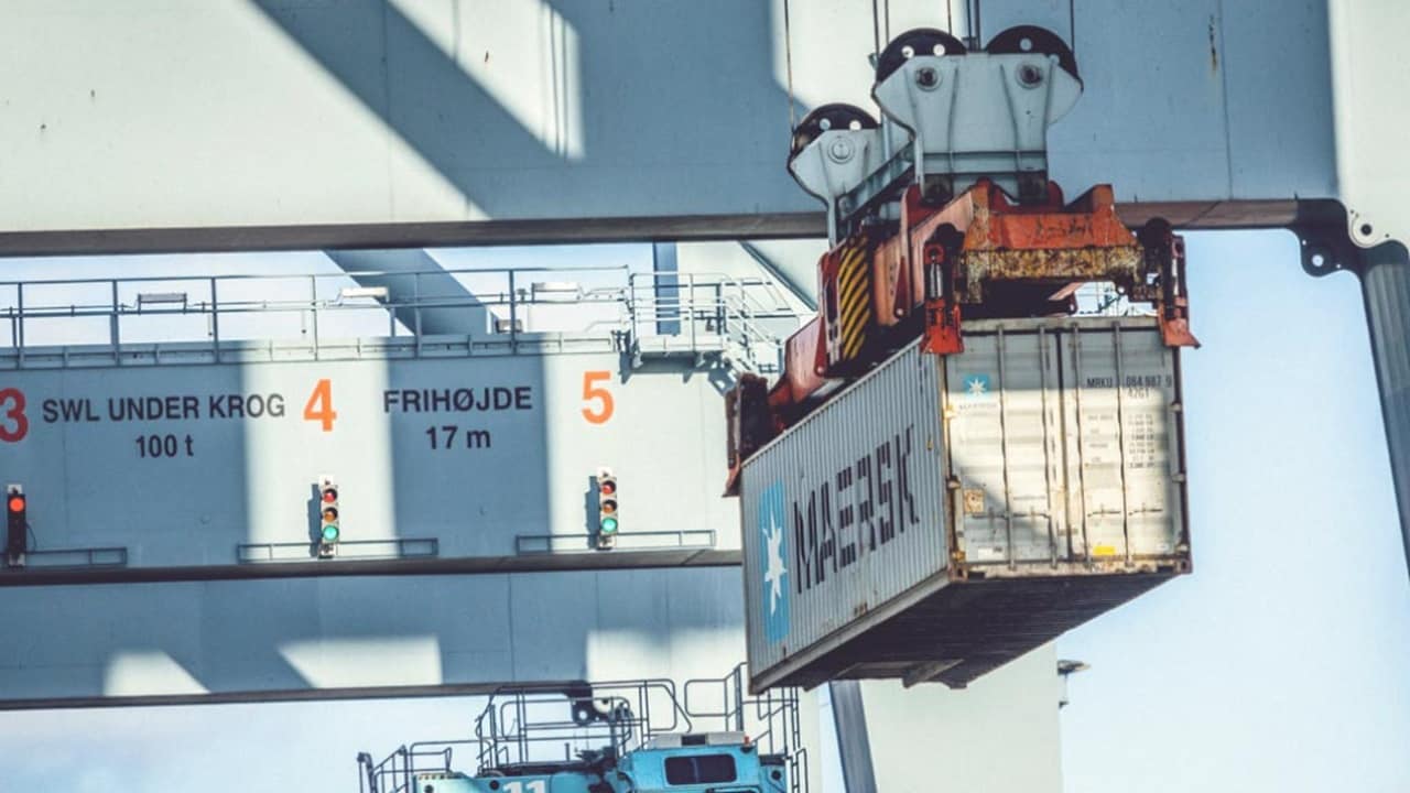 A Maersk cargo container being lifted by a ship crane
