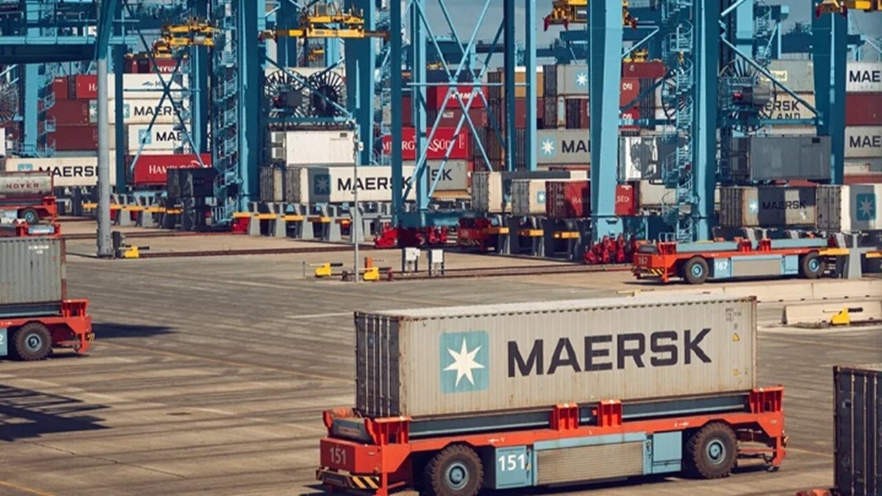 A busy cargo port with multiple Maersk shipping containers.